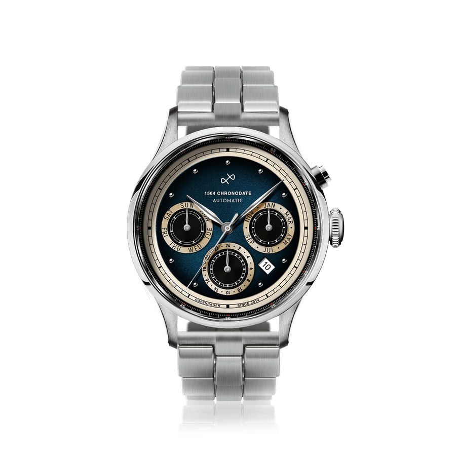 1564 Chronodate Automatic, Steel / Blue by AV86 features a vintage-inspired automatic chronograph with a sunburst blue dial, three cream subdials for day, month, and 24-hour time, housed in a polished stainless steel case with sapphire crystal, paired with a brushed steel bracelet, exemplifying Danish design and Nordic minimalism.