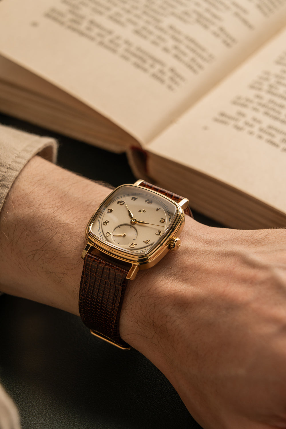 1954 Amalfi Mechanical by AV86 with polished cushion case, vintage off-white dial, small seconds, and textured leather strap worn reading book
