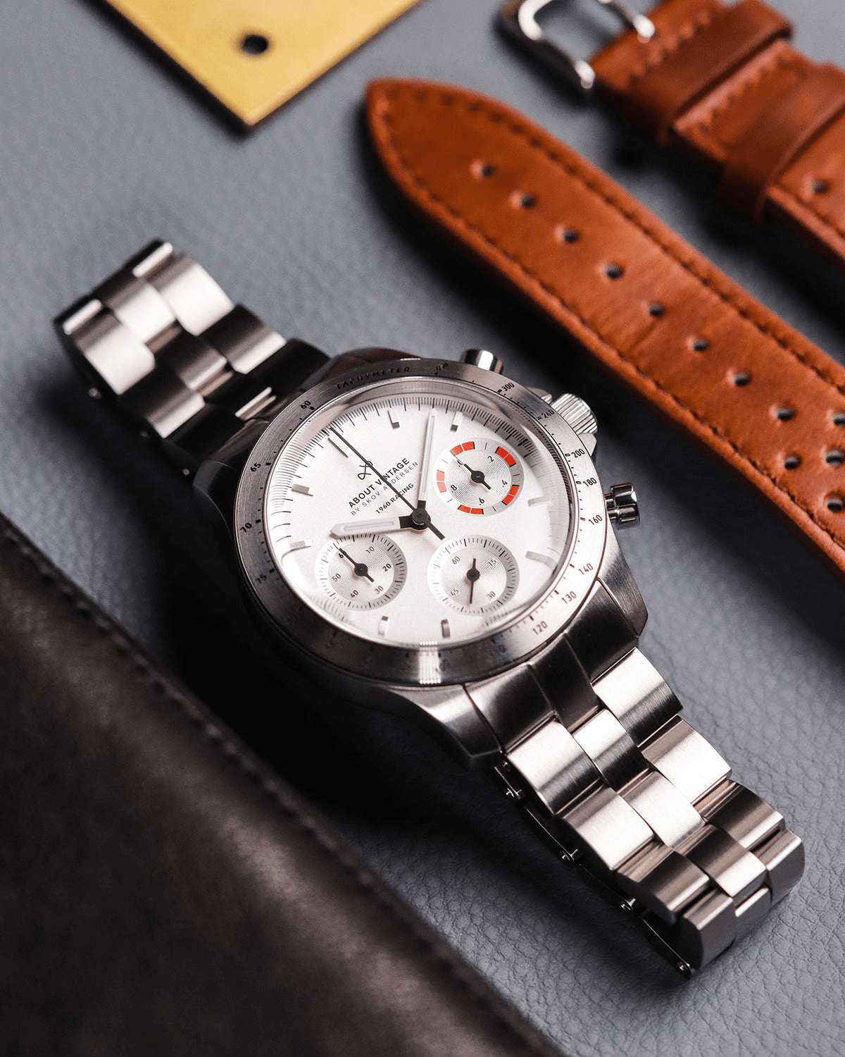 AV86의 1960 Racing Chronograph. 빈티지 스타일의 다이얼, Sapphire Crystal, 타키미터 베젤, 브러시드 스틸 브레이슬릿 스트랩이 특징입니다.