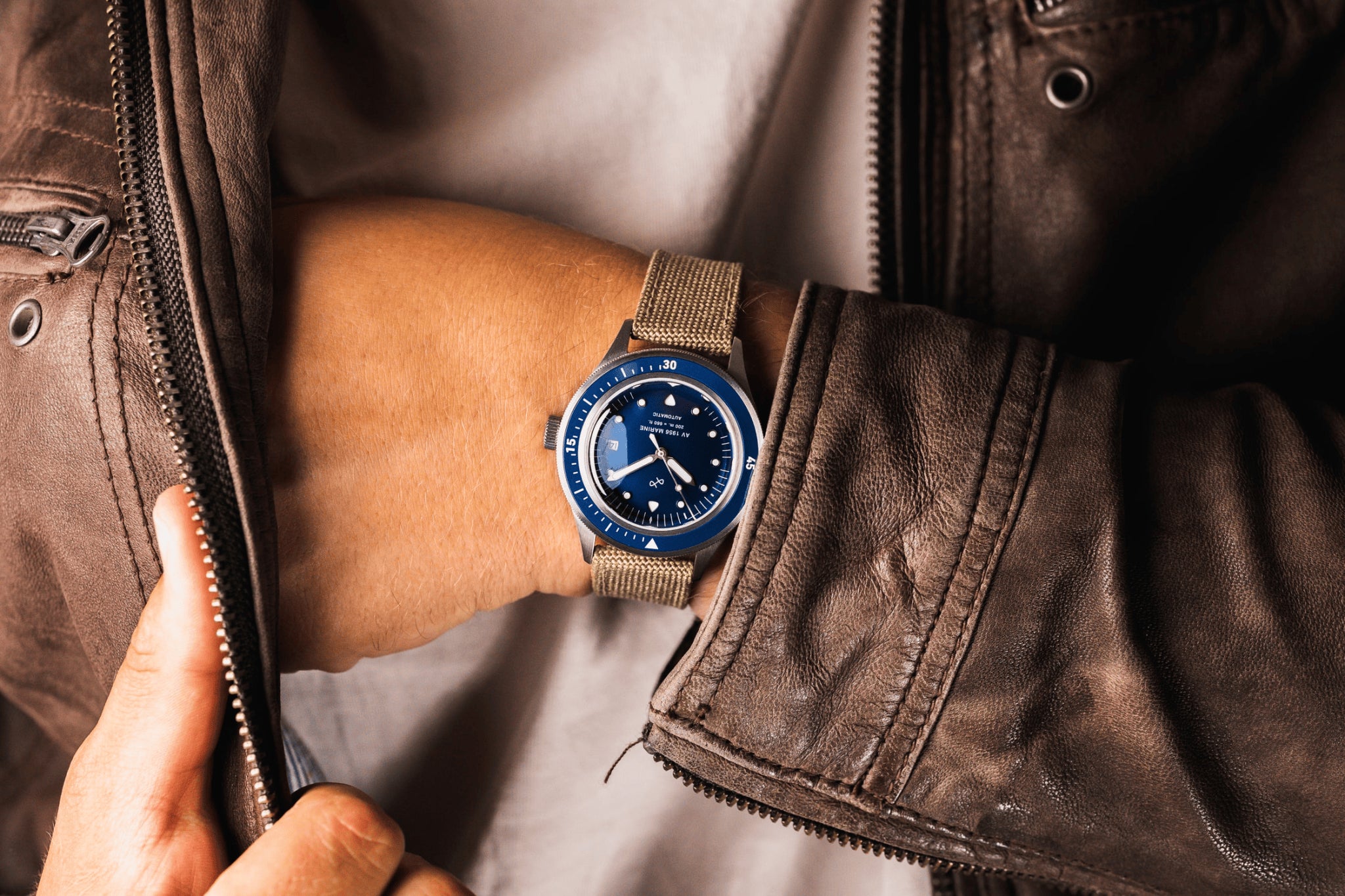 AV86의 1956 Marine Automatic: 빈티지 감성의 다이버 워치로, Sapphire Crystal, 나침반 베젤, 베이지색 패브릭 스트랩을 갖추고 있습니다.