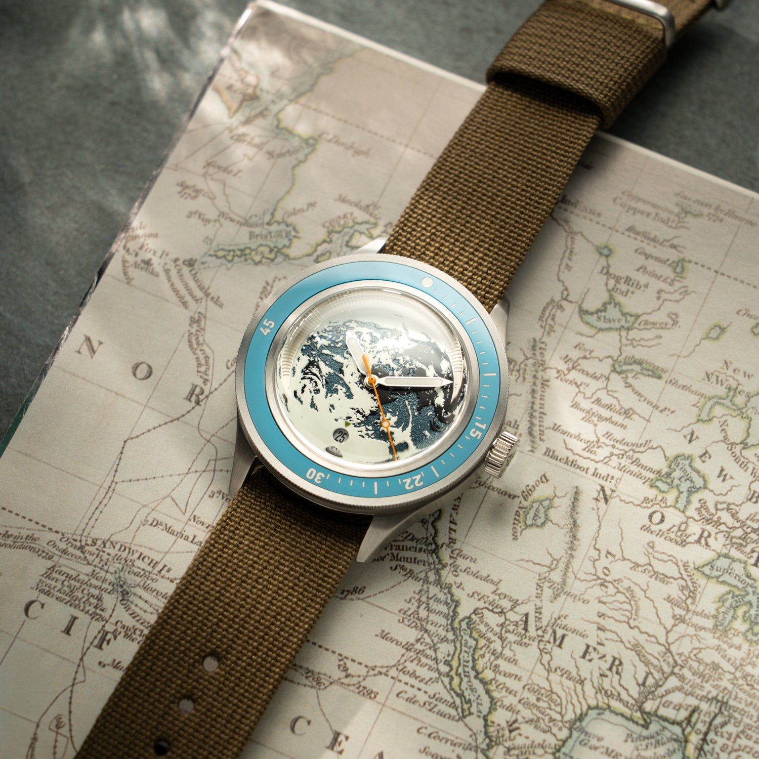 Uhr „Earthrise WWF Partnership, Automatic / 2026 Edition“ von AV86 mit Vintage-inspiriertem Design auf einem Kartenhintergrund