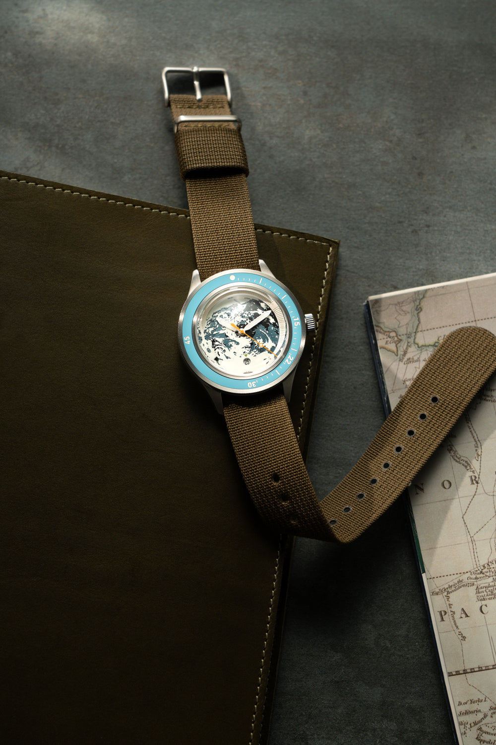 Partenariat Earthrise WWF, modèle Automatique / Édition 2026 par AV86, avec lunette bleue et bracelet en tissu marron, accompagné d'une carte et d'un étui en cuir