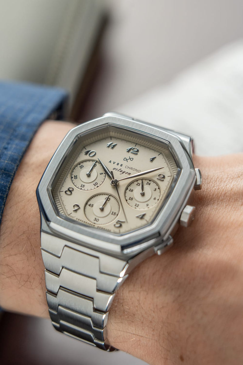 1904 Chrono, Steel / Off White luxury chronograph on wrist featuring a hexagonal stainless steel case, off white dial with three subdials, and integrated steel bracelet by AV86, embodying Nordic minimalism and Copenhagen design craftsmanship.