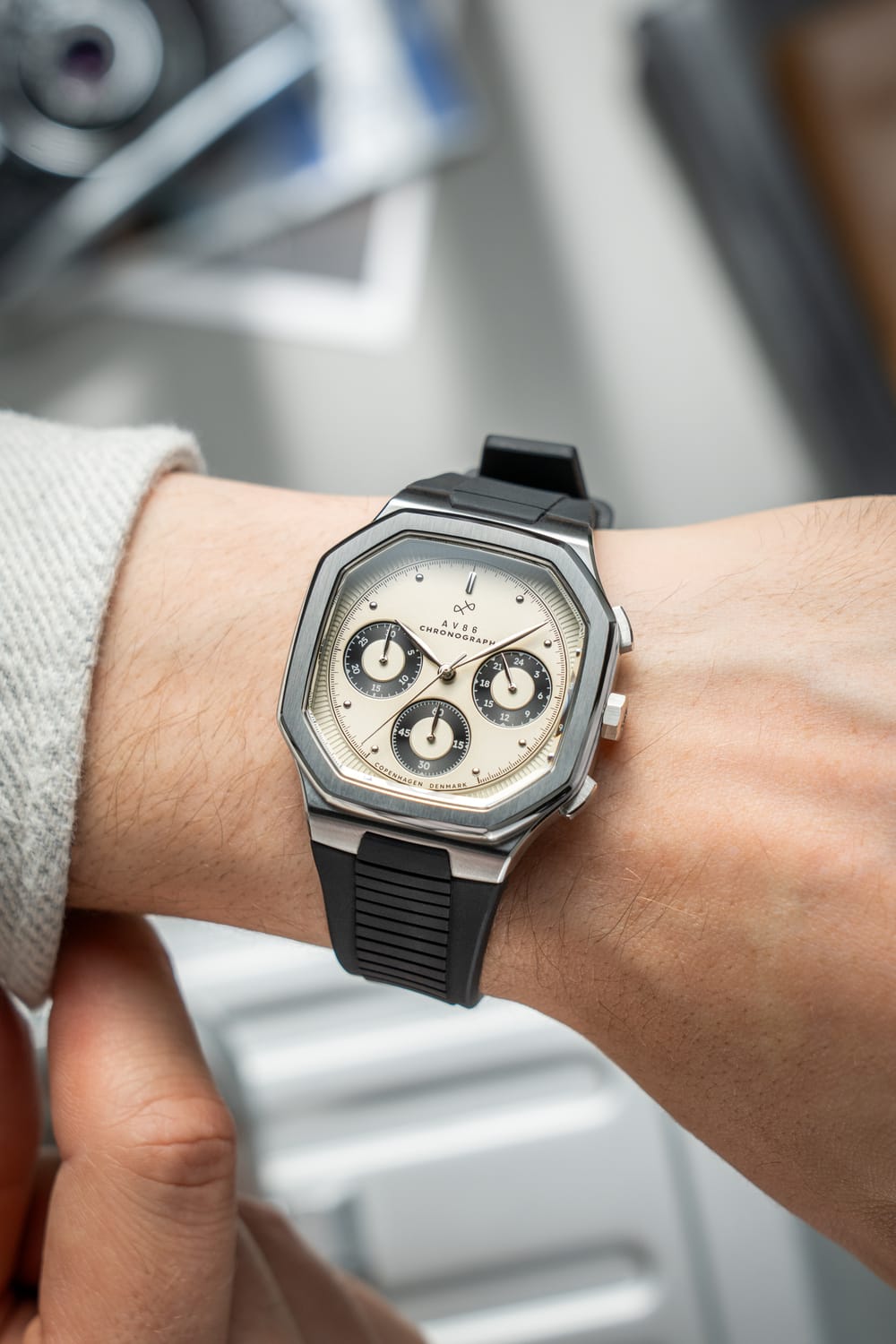 AV86의 1904 Chronograph. 각진 케이스, Sapphire Crystal, 크로노그래프 서브 다이얼, 그리고 손목에 착용된 블랙 러버 스트랩