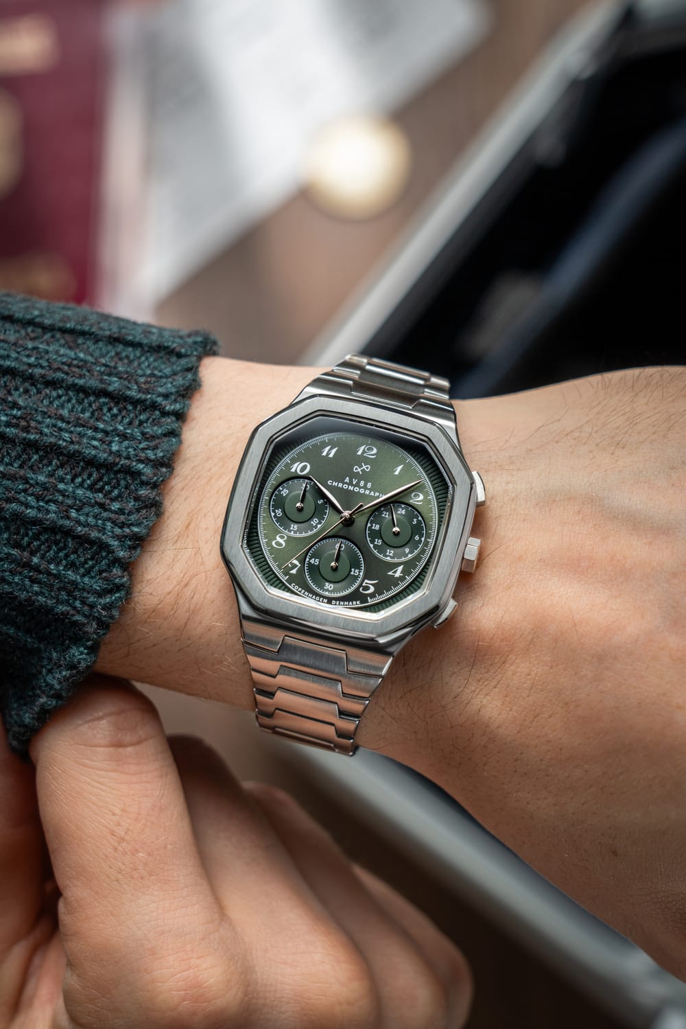 AV86製1904 Chronograph。角張ったケース、オリーブグリーンの文字盤、Sapphire Crystal、クロノグラフのサブダイヤル、そしてスチール製リンクストラップを備えています