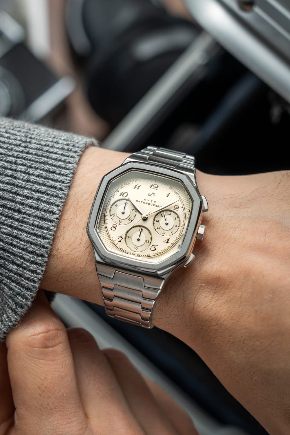 AV86의 1904 Chronograph. 각진 케이스, Sapphire Crystal, Chronograph 다이얼, 브러시드 메탈 브레이슬릿 스트랩이 특징입니다.
