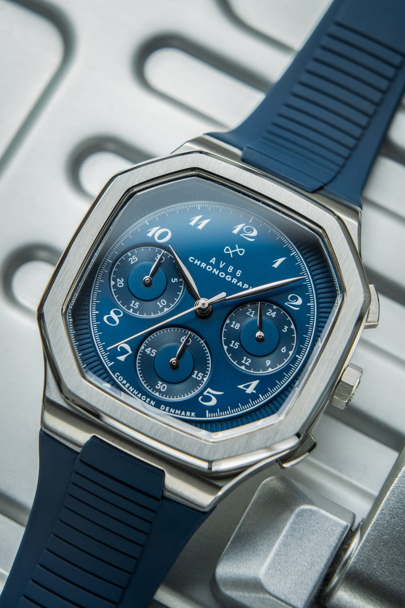 1904 Chronograph by AV86 with defined angular case, sapphire crystal, blue dial, chronograph subdials, and textured rubber strap