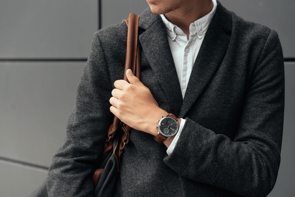 1815 Chronograph by AV86 with vintage-inspired dial, sapphire crystal, chronograph function, and brown leather strap on wrist in urban attire