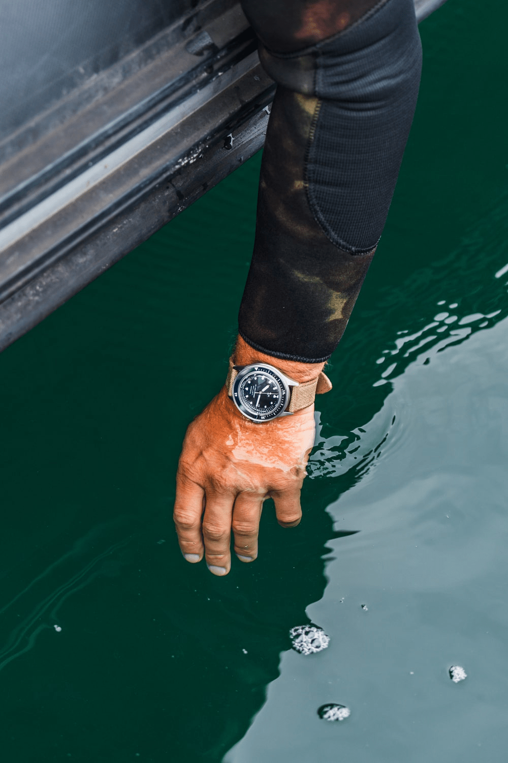 1956 Marine Automatic by AV86 vintage-inspired diver with compass bezel, sapphire crystal, and textured fabric strap in a marine setting