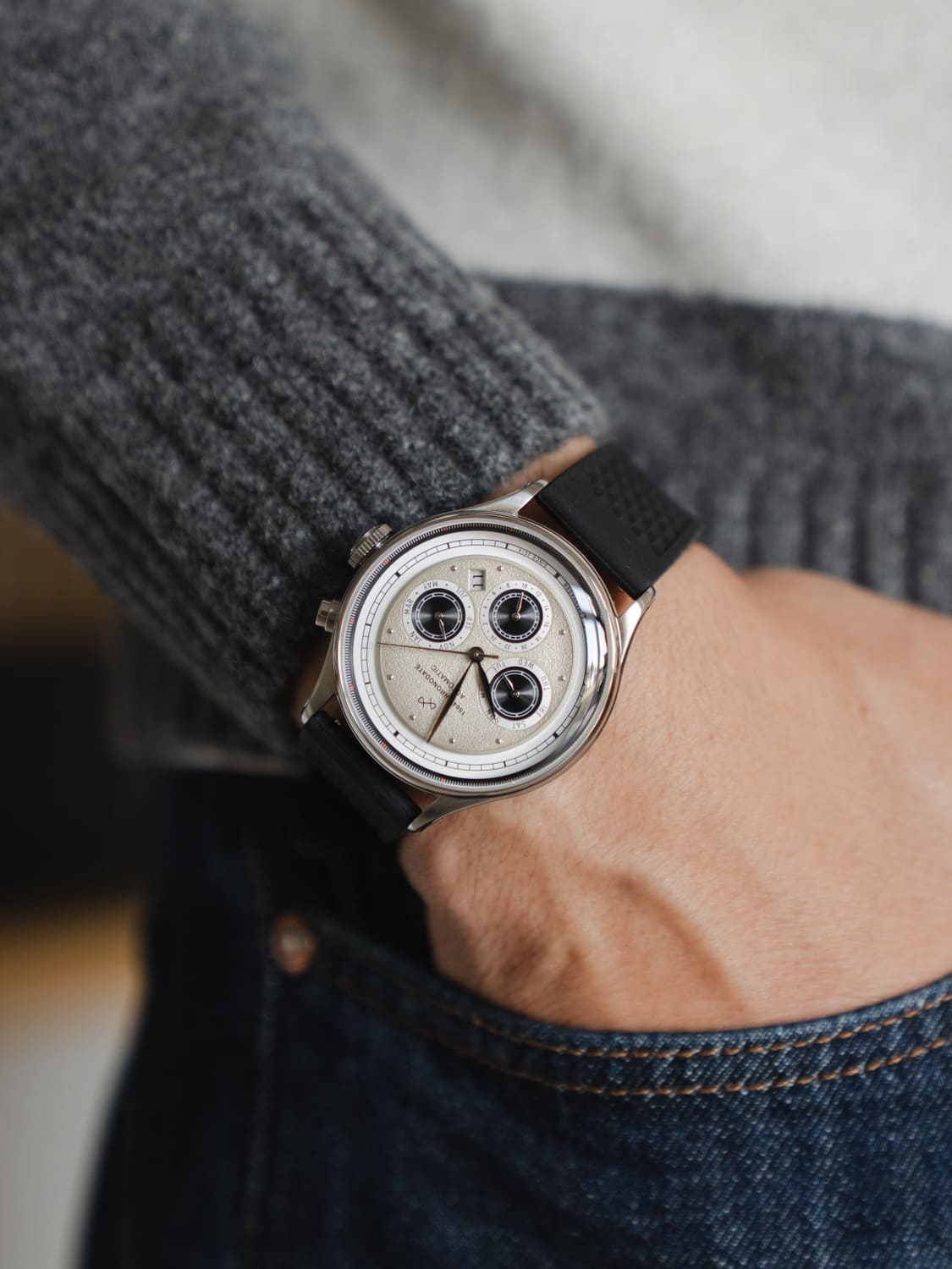 1564 Chronodate Automatic by AV86 featuring vintage-inspired chronograph dial, sapphire crystal, date window, and black rubber strap on wrist.