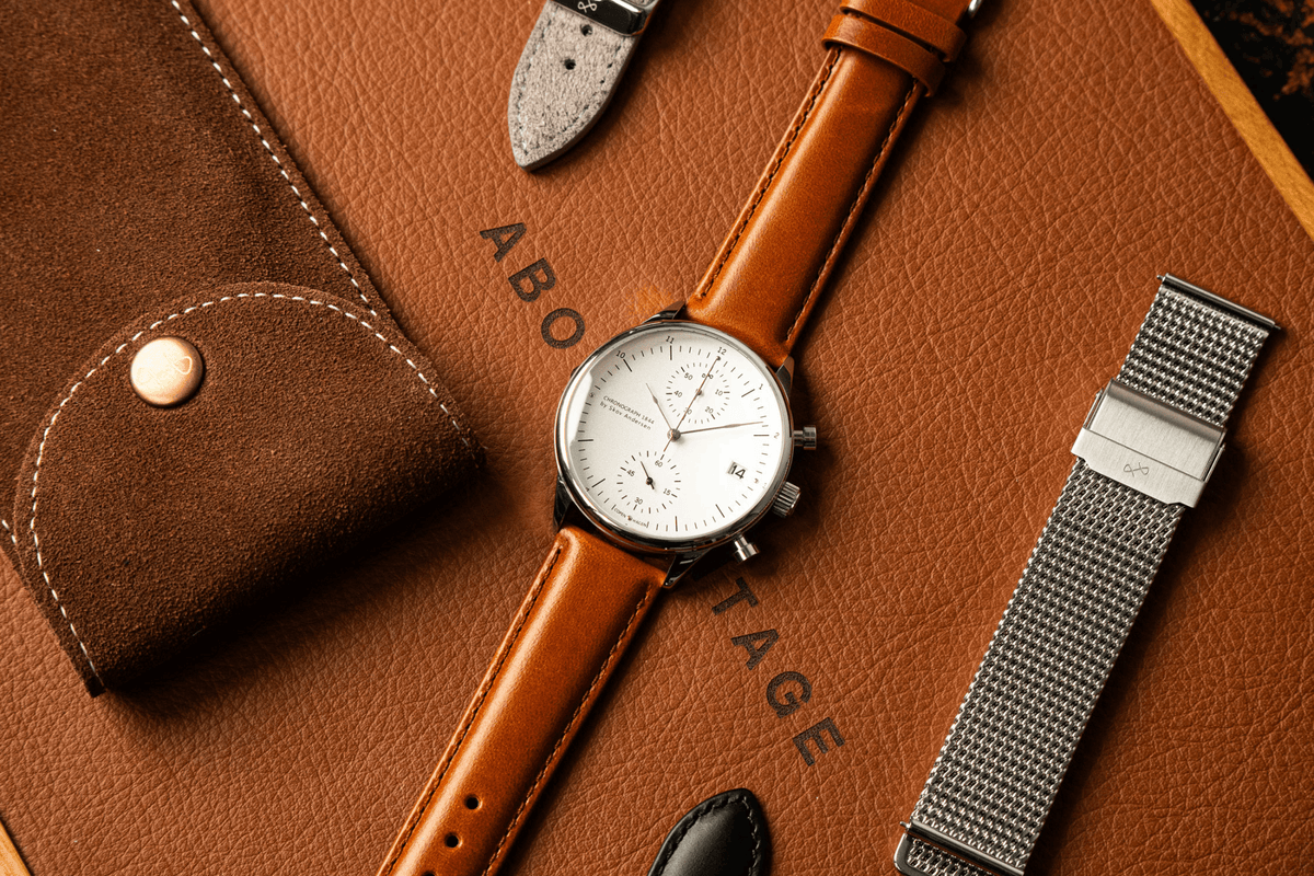 AV86의 1844 Chronograph 럭셔리 시계로, 빈티지 스타일의 다이얼과 Sapphire Crystal, 가죽 마감 처리된 브라운 가죽 스트랩이 특징입니다.
