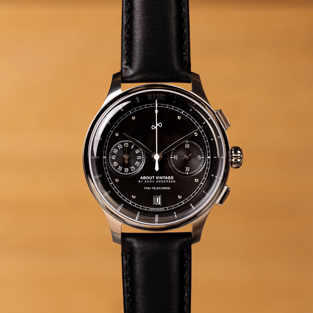 1934 Telechron, a luxury chronograph by AV86 with a black dial, dual subdials, date window, polished steel case, sapphire crystal, and black leather strap, embodying Scandinavian horological excellence and minimalist design.