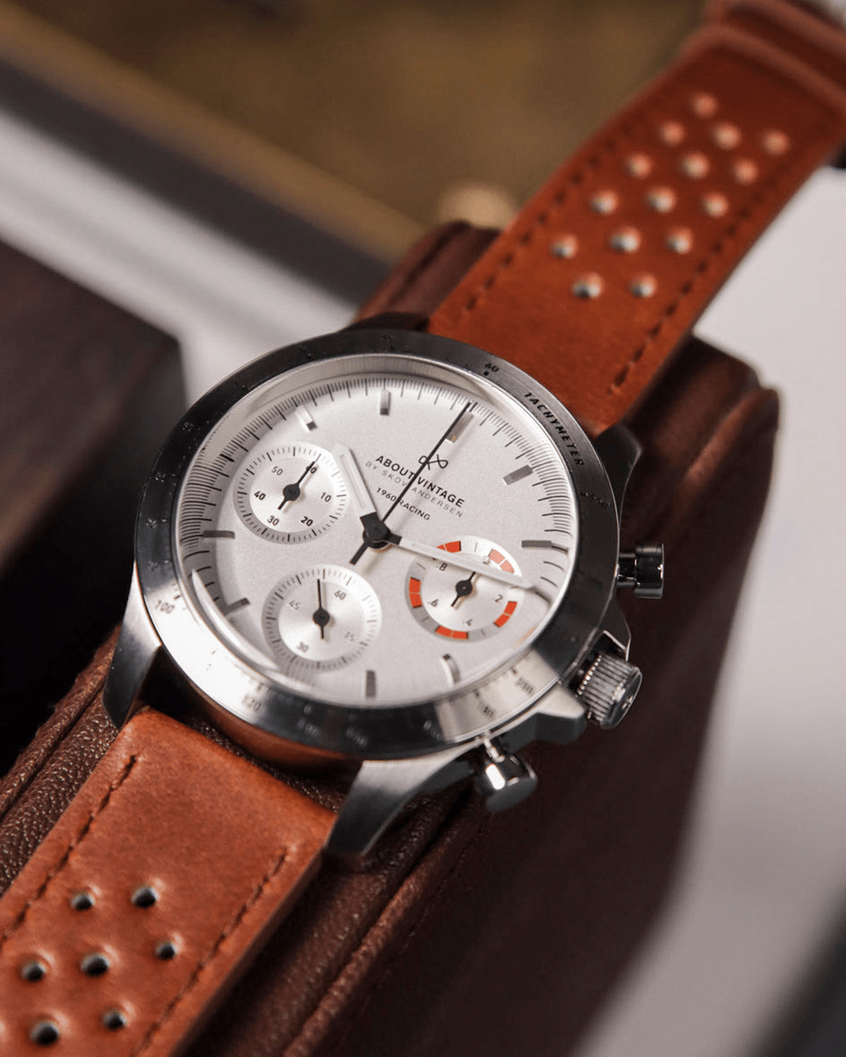 AV86의 1960 Racing Chronograph. Sapphire Crystal, 타키미터 베젤, 빈티지 스타일 다이얼, 그리고 천공 가죽 스트랩이 특징입니다.