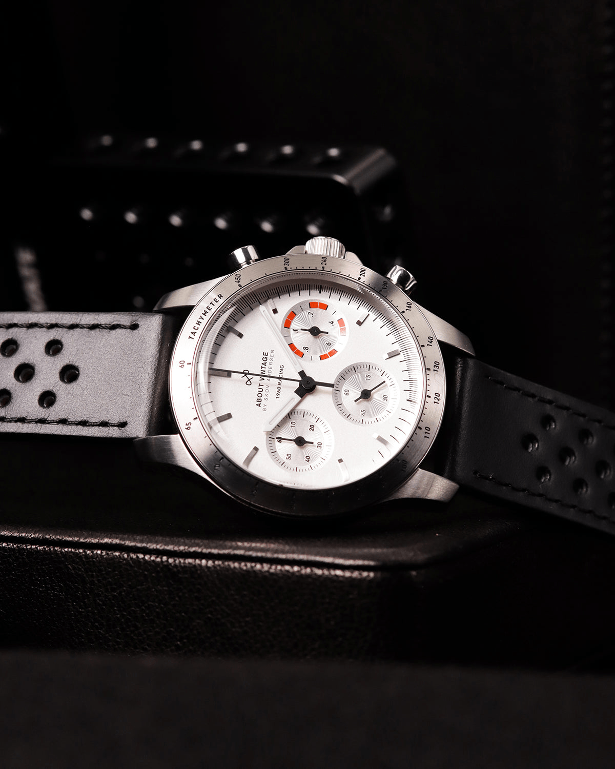 AV86의 1960 Racing Chronograph: 빈티지 스타일의 다이얼, Sapphire Crystal, 타키미터 베젤, 그리고 천공 가죽 스트랩이 특징입니다.