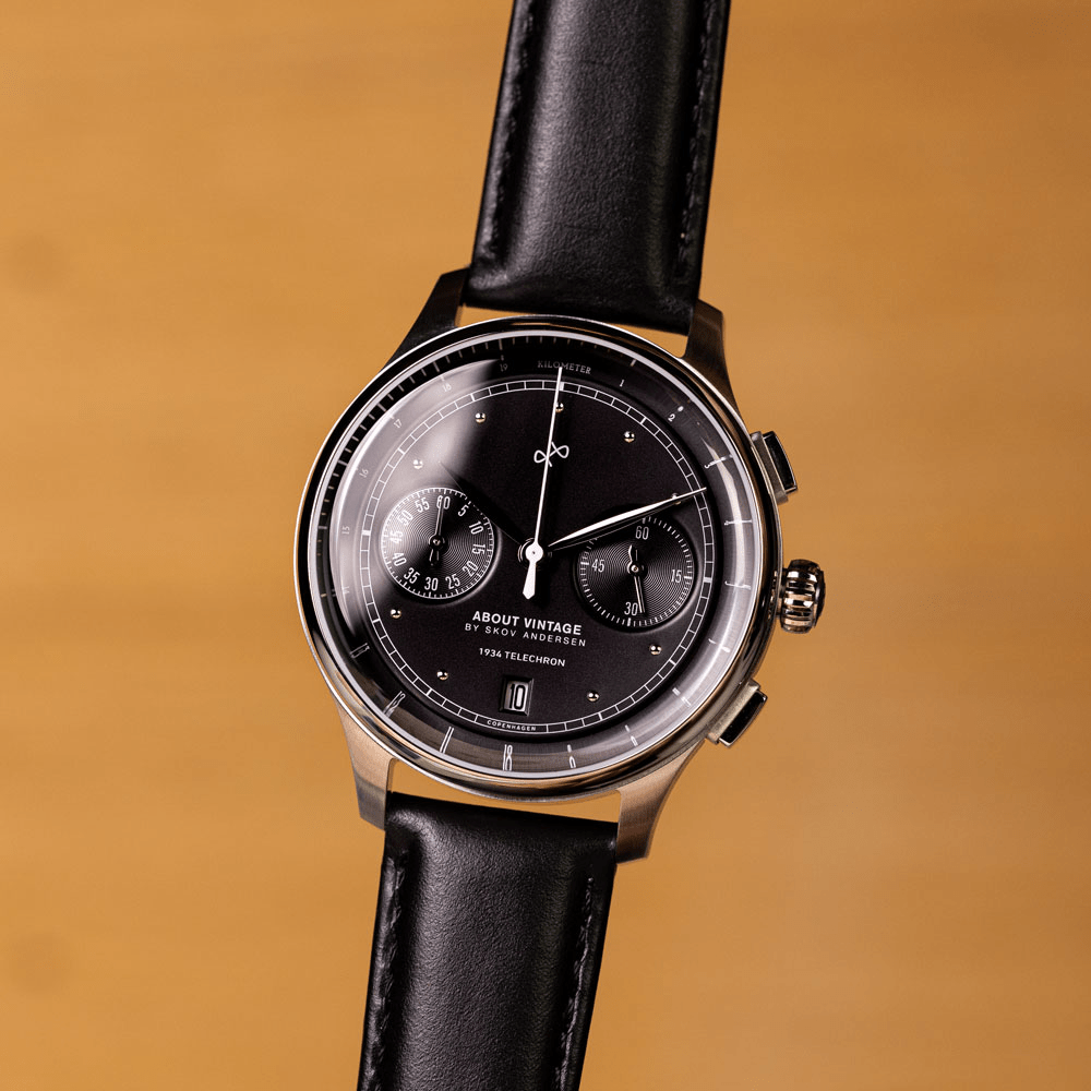 1934 Telechron by AV86 features a vintage-inspired chronograph with a black dial, dual subdials, date window, sapphire crystal, polished steel case, and black leather strap, exemplifying Nordic minimalism and horological excellence.