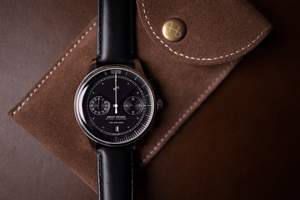 1934 Telechron, Steel / Black by AV86 showcases a refined chronograph with a black dial, dual subdials, date window, sapphire crystal, and a smooth black leather strap reflecting Scandinavian minimalist luxury.