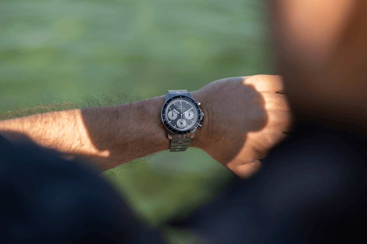 1960 Racing Chronograph by AV86 vintage-inspired chronograph with sapphire crystal, steel case, and metal bracelet strap on wrist outdoors