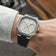 Wrist wearing the 1904 Chrono by AV86, a luxury chronograph with vintage-inspired off white dial, hexagonal steel case, and black textured rubber strap, capturing Nordic minimalism in a casual setting.