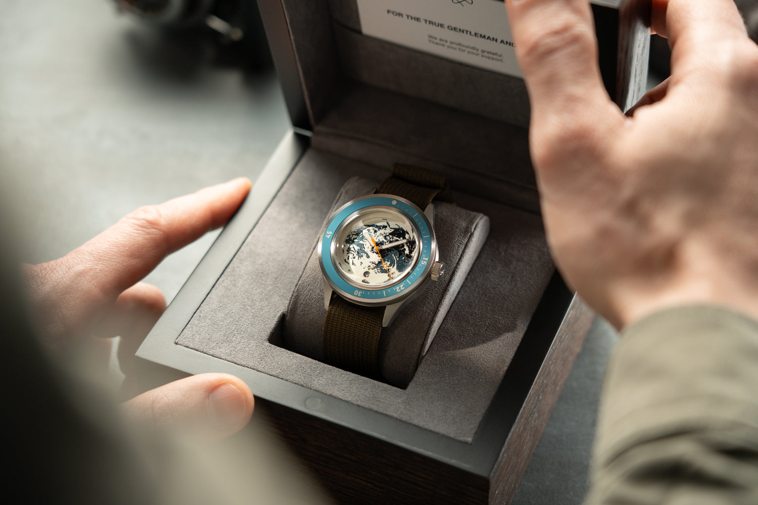 Earthrise WWF Partnership, Automatik / 2026 Edition von AV86 – Luxusuhr mit grünem Armband in einer Präsentationsbox, von Zeigern gehalten