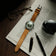 1956 Marine Automatic, Steel / Green watch with brown leather strap by AV86 on newspaper with glasses and fountain pen nearby