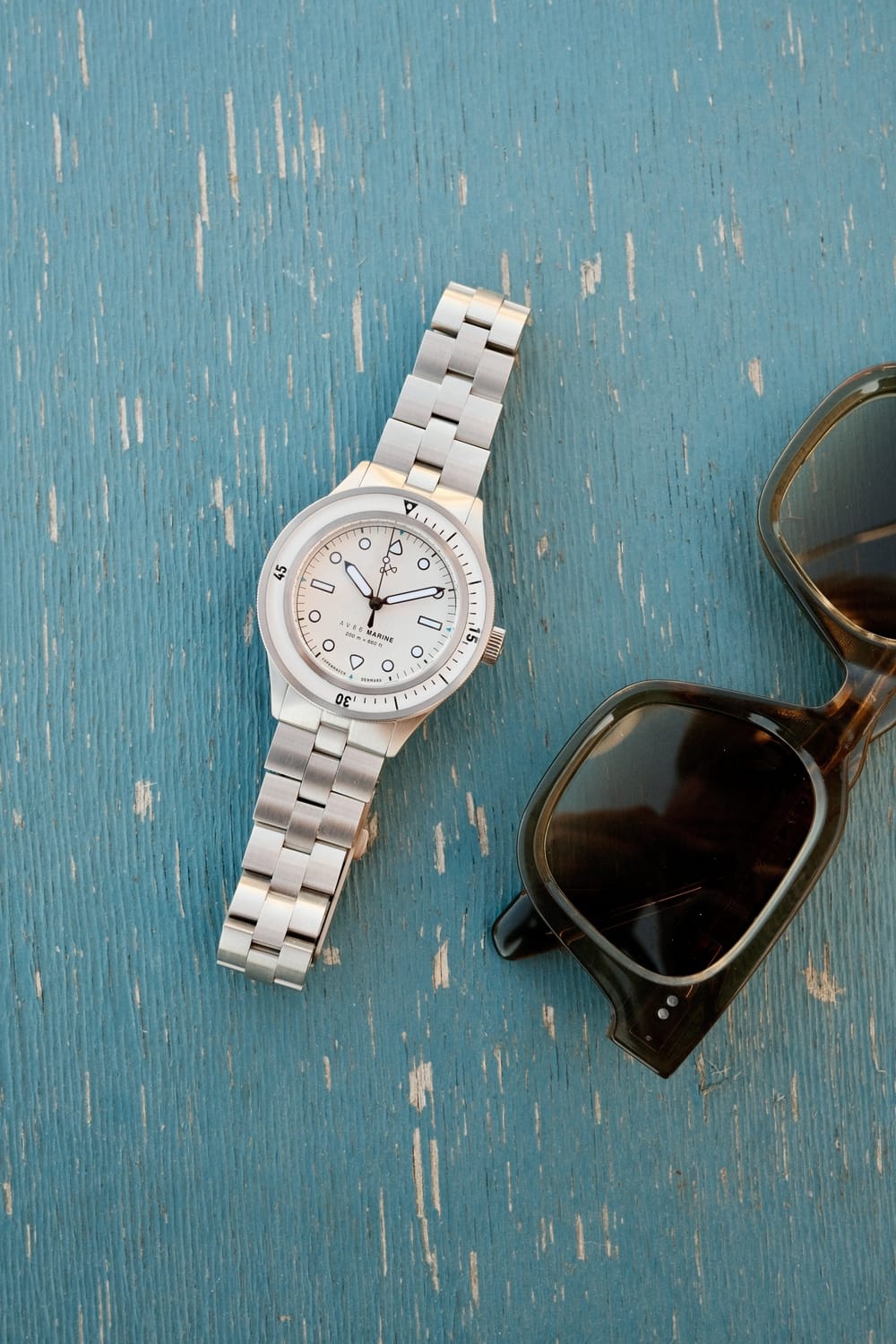 1956 Marine by AV86 vintage-inspired diver with sapphire crystal, stainless steel case, bezel, and metal bracelet strap on textured surface