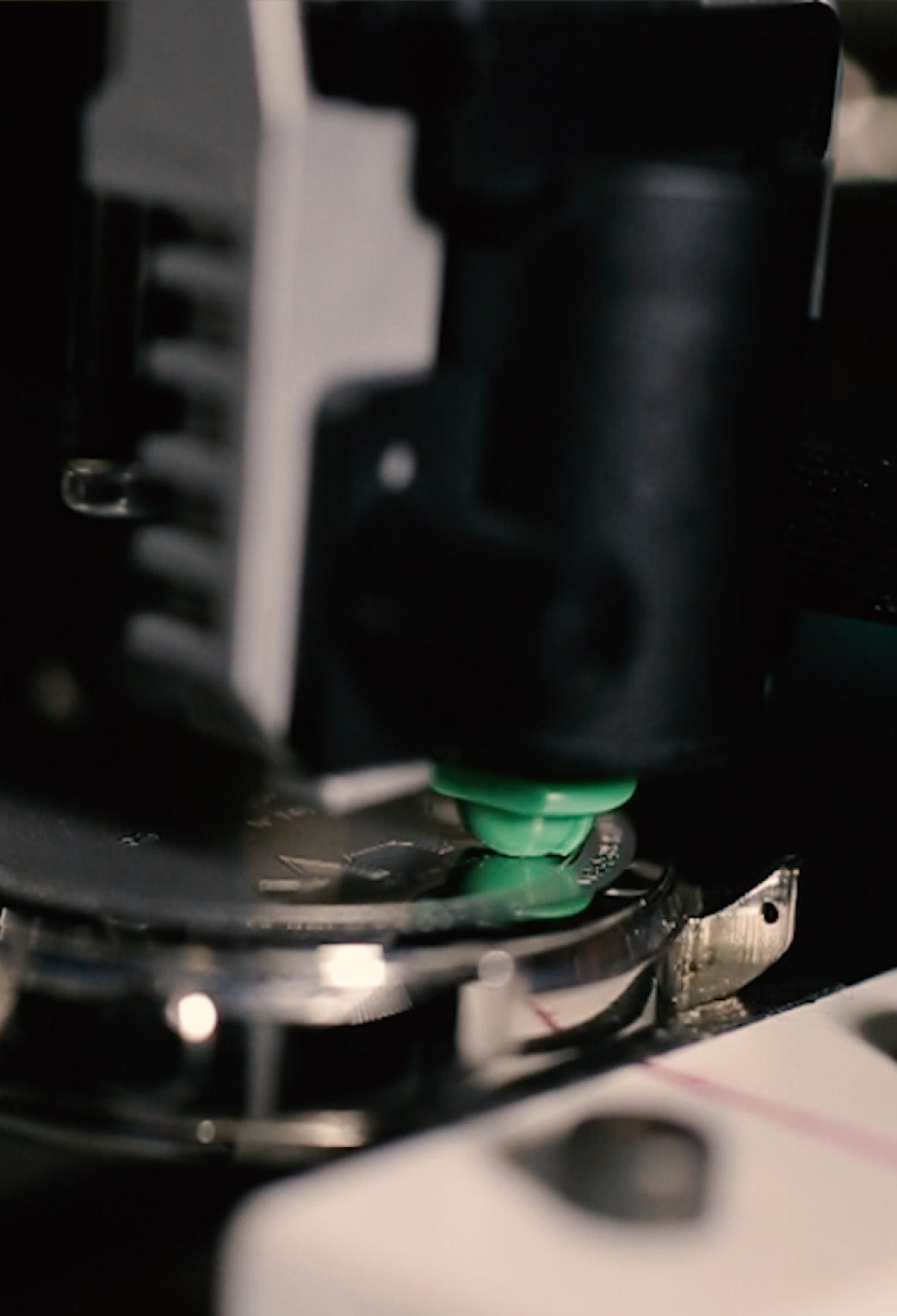 Close-up of precision machinery engraving or assembling a luxury watch case, highlighting fine craftsmanship and detail