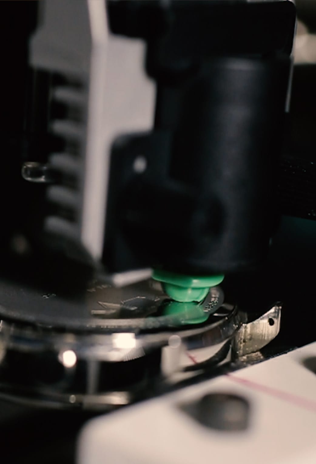 Close-up of precision machinery engraving or assembling a luxury watch case, highlighting fine craftsmanship and detail