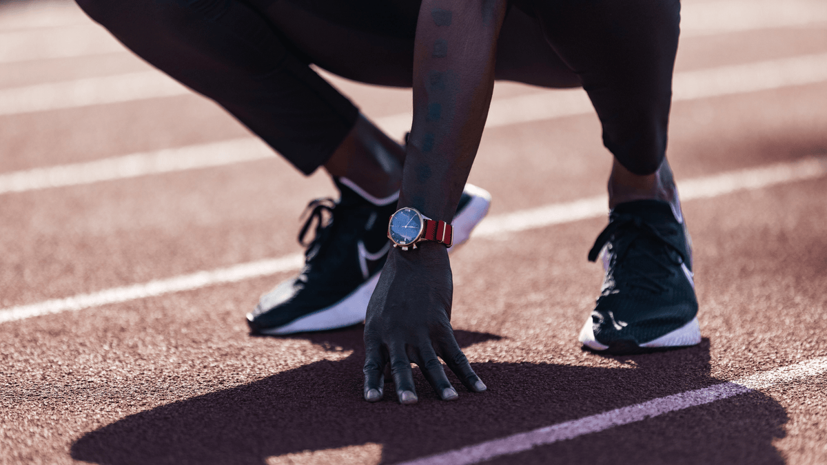1815 Justin Gatlin von AV86: ein Chronograph im Vintage-Stil mit Saphirglas und rotem Stoffarmband am Handgelenk des Sprinters