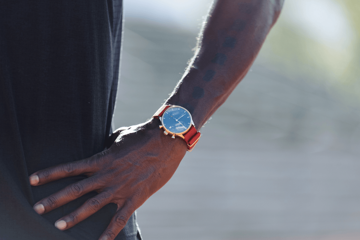 1815 Justin Gatlin, Gold / Blue Turtle fra AV86 – luksus-Chronograph med Sapphire Crystal og orange læderrem på håndleddet udendørs